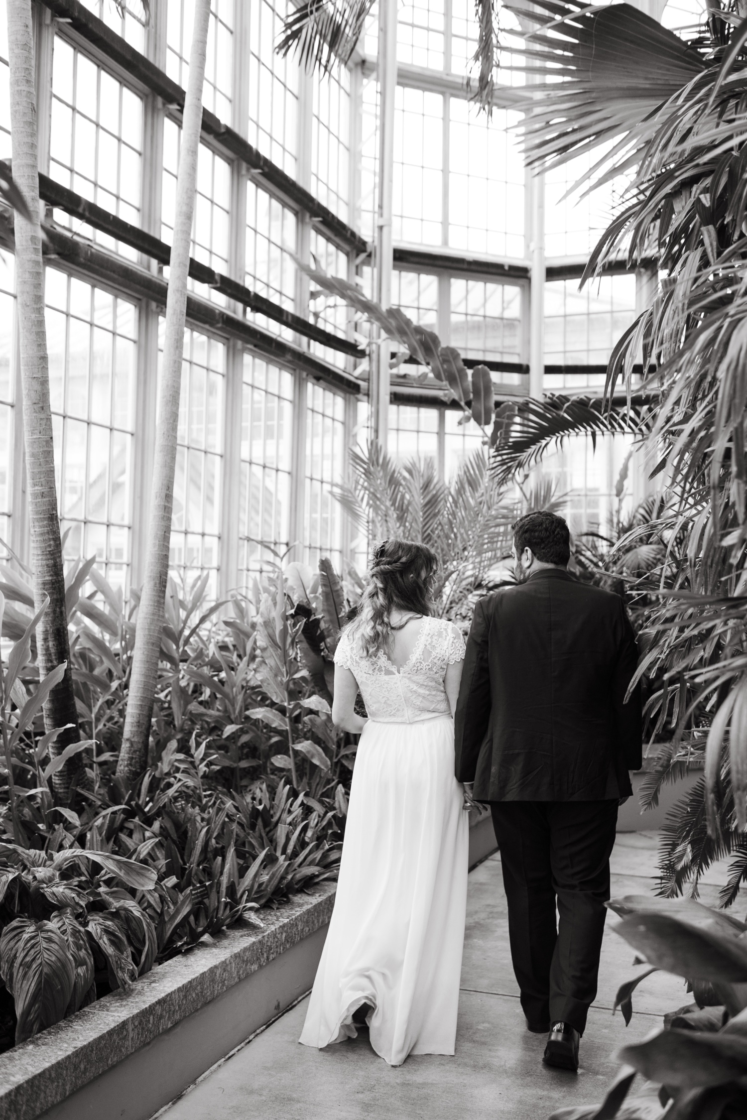 bride and groom wedding day walking through greenhouse
