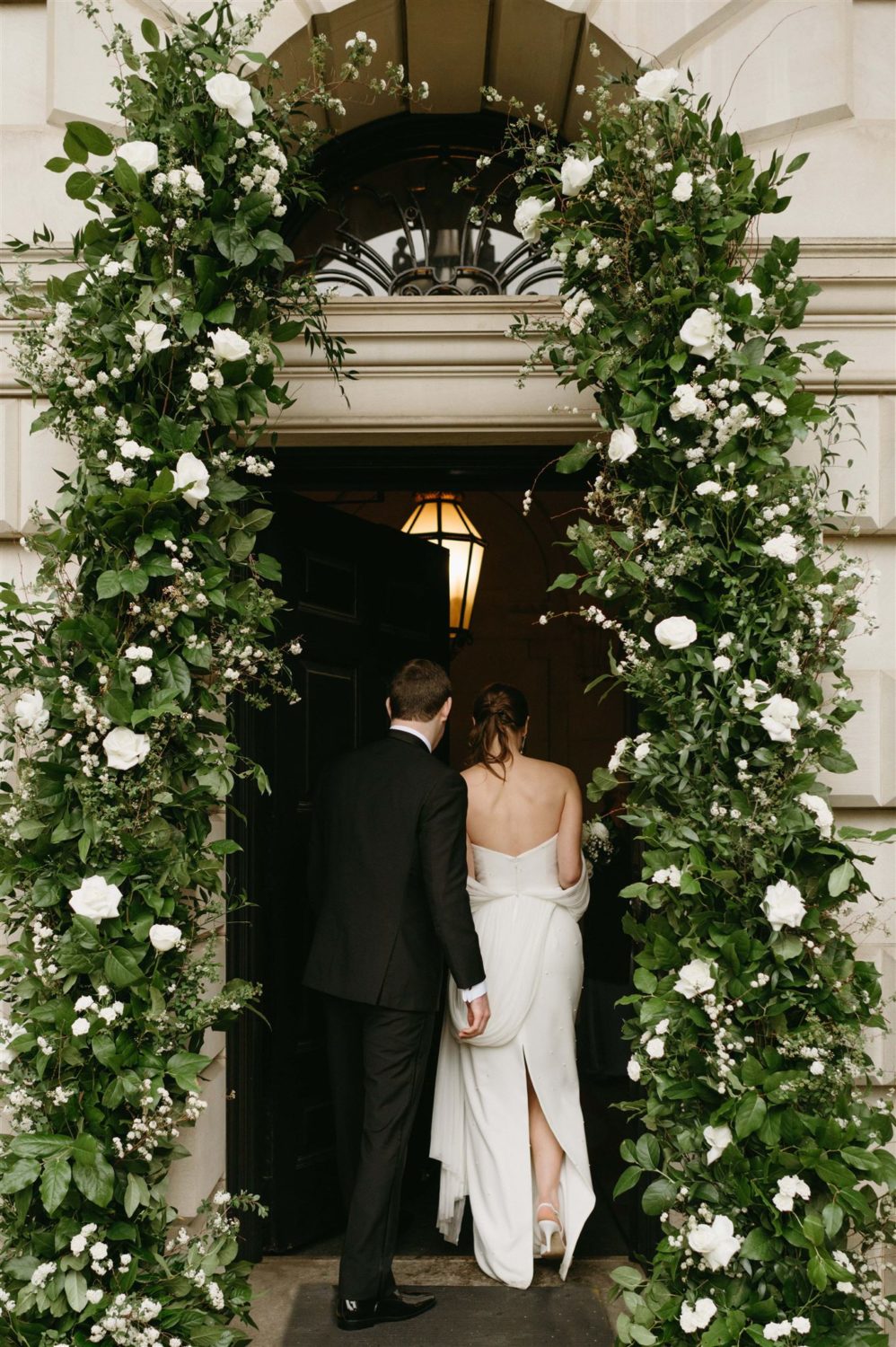 bride and groom entering reception flower archway
