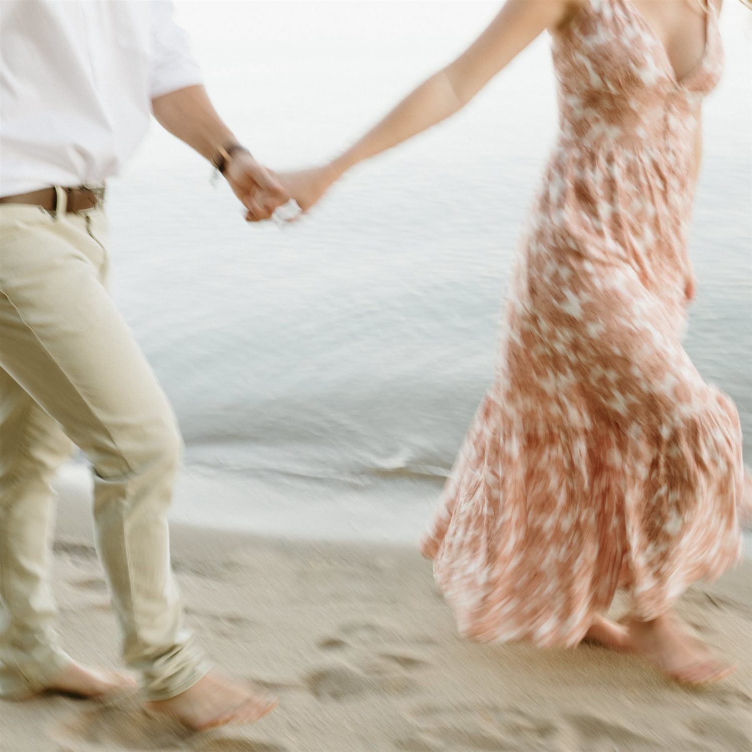 couple holding hands beach engagement