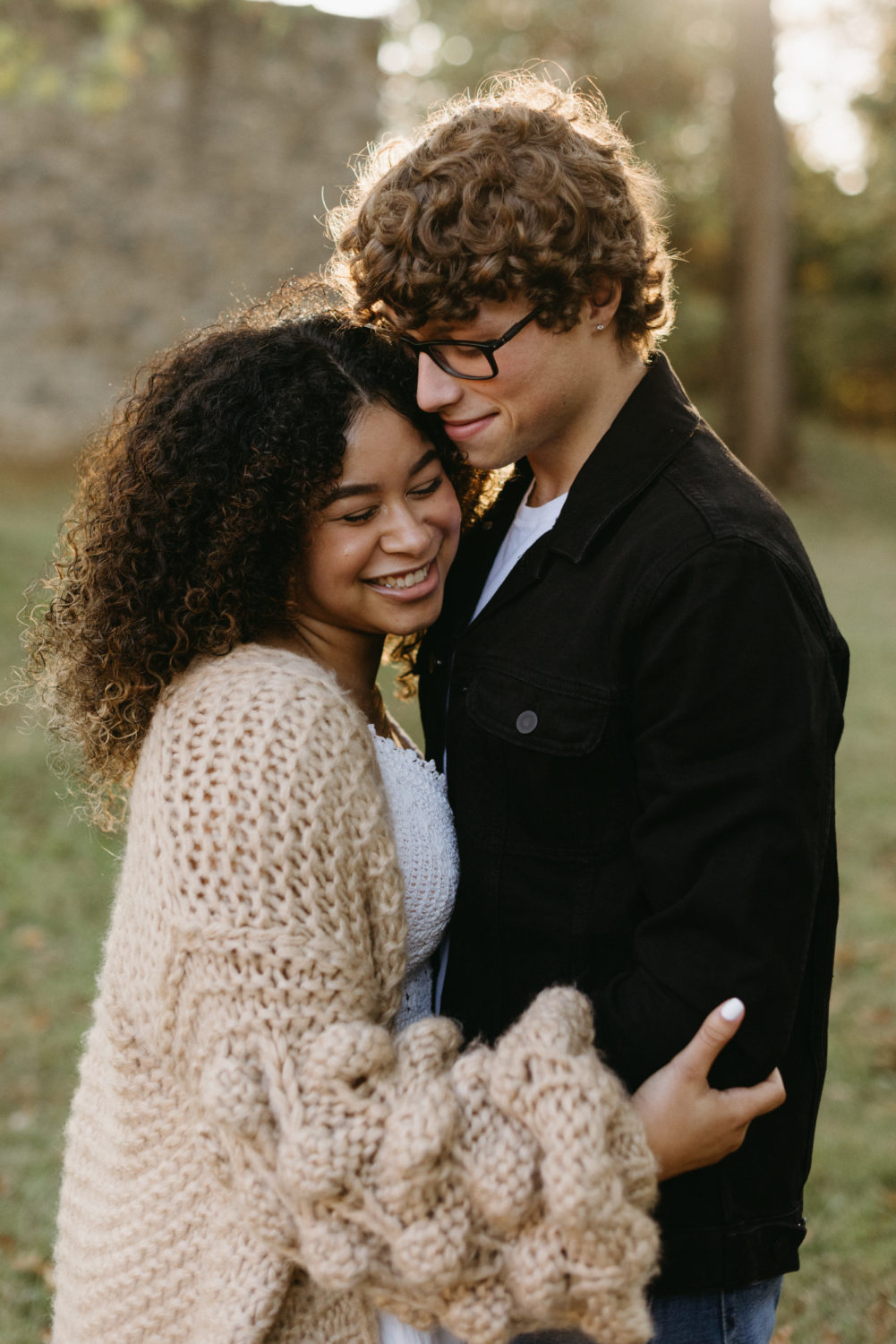 engagement session outfits fall couple hugging smiling