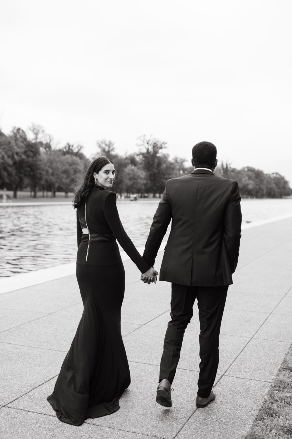 couple walking holding hands black and white