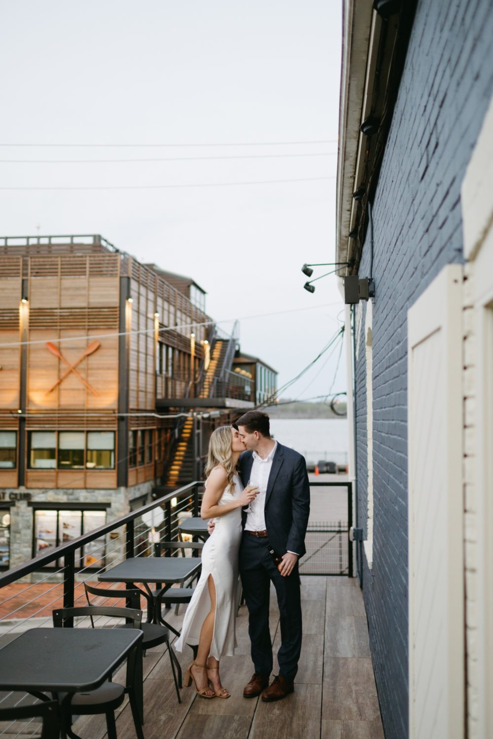 couple kissing holding drinks rooftop