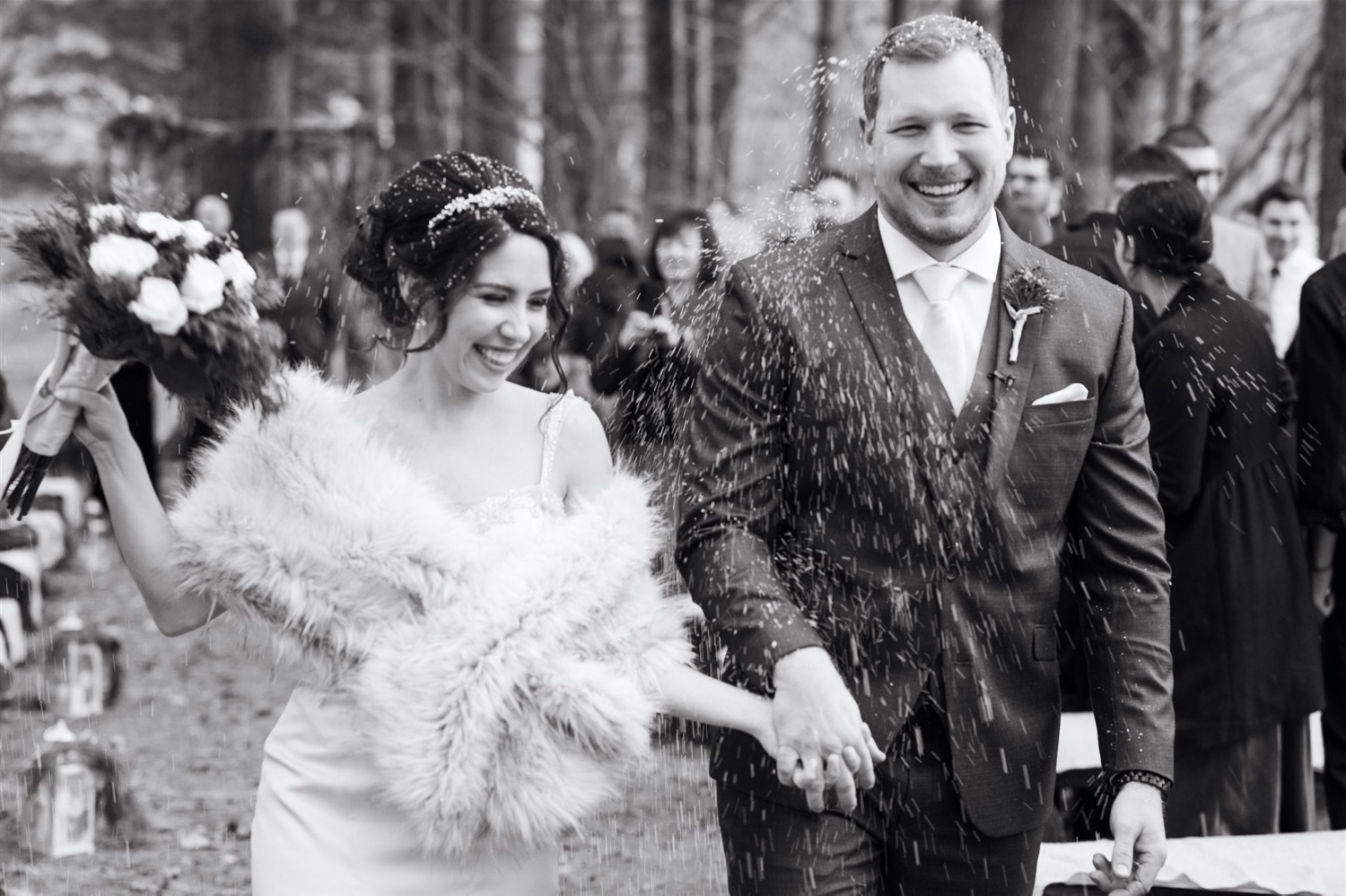 bride and groom ceremony exit snowing black and white