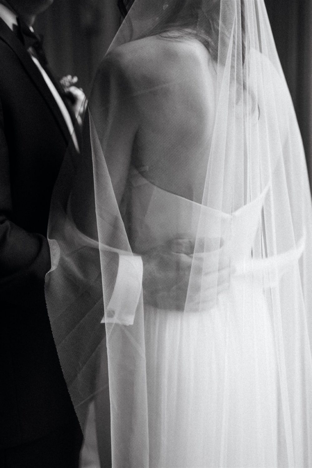 black and white film bride and groom hugging