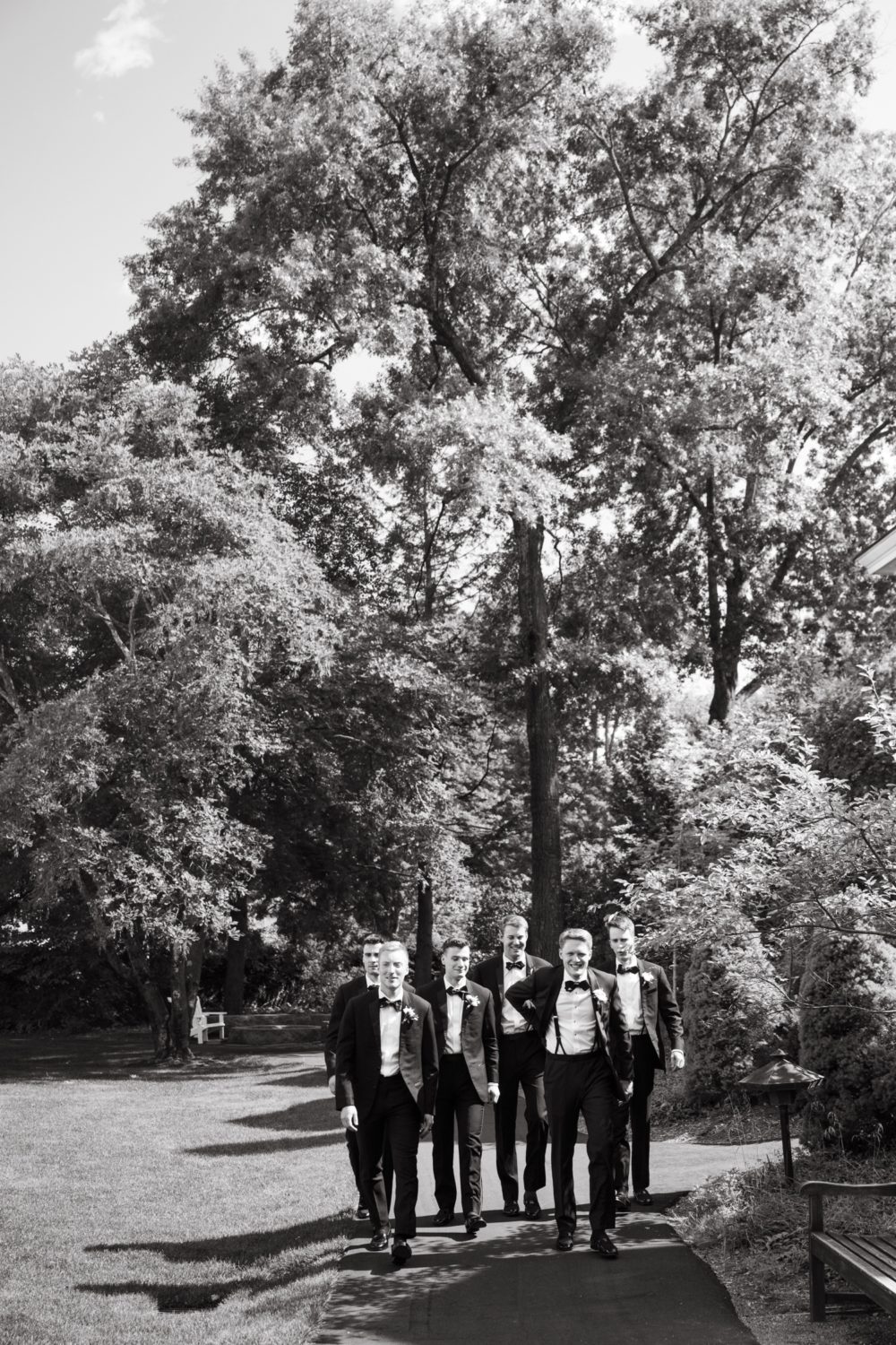 black and white woodstock inn wedding groomsmen walking