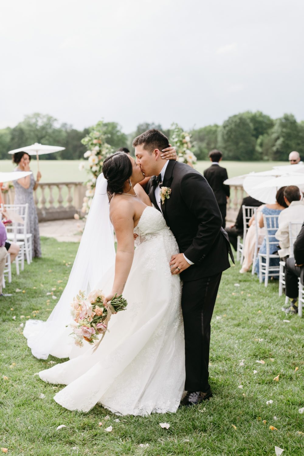 bride and groom kissing ceremony aisle