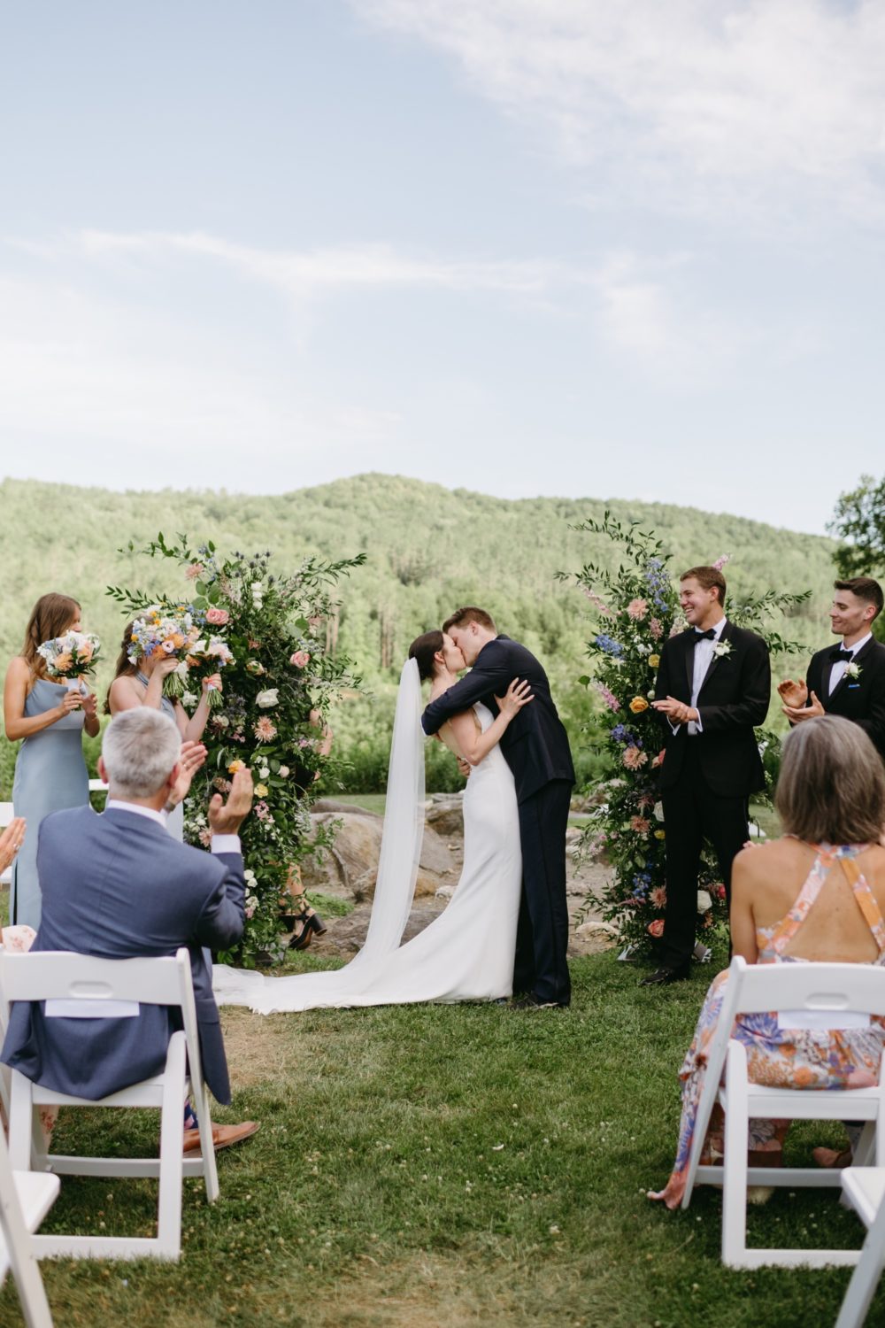 woodstock inn wedding bride and groom kissing hugging florals