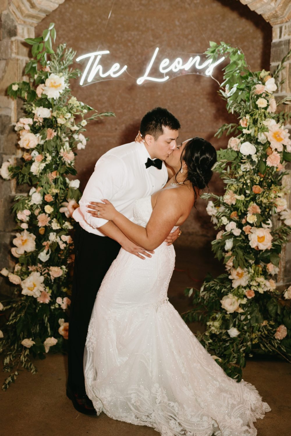 soiree great marsh estate bride and groom kissing floral details neon sign