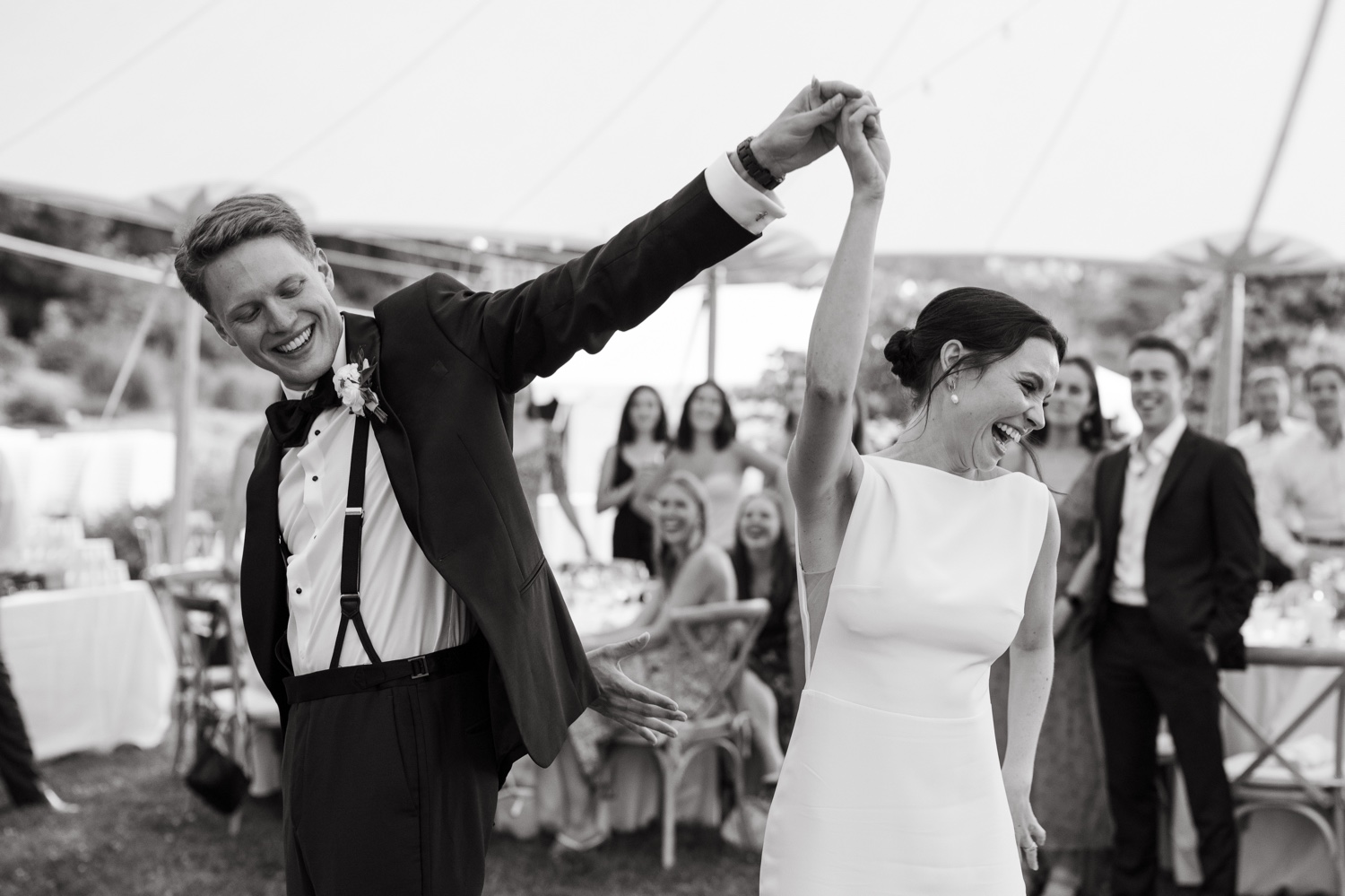 bride and groom dancing holding hands black and white