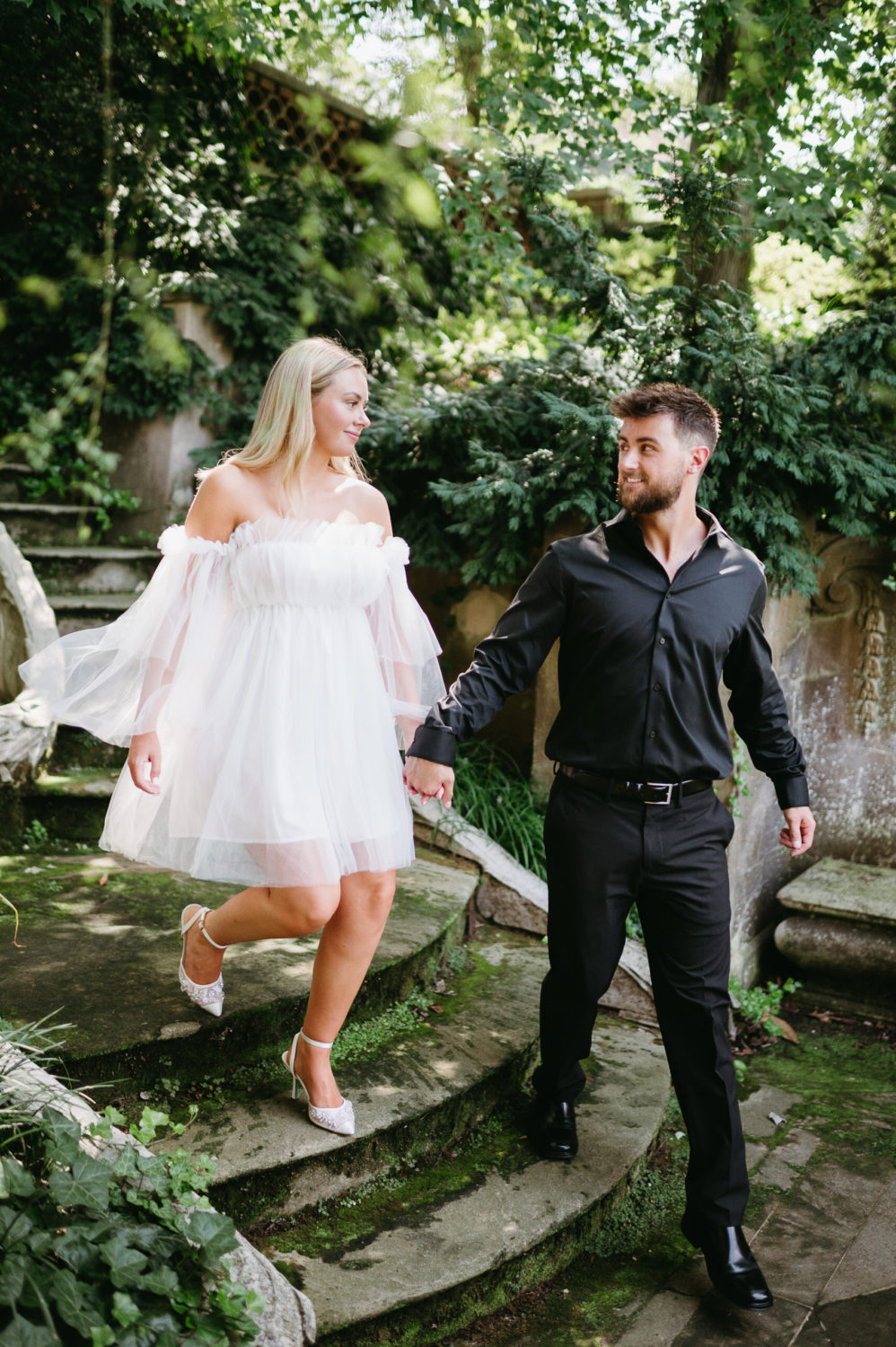 engagement shoot botanical gardens couple holding hands white tulle dress