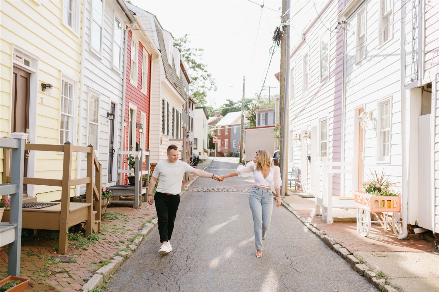 engaged couple holding hands walking alleyway
