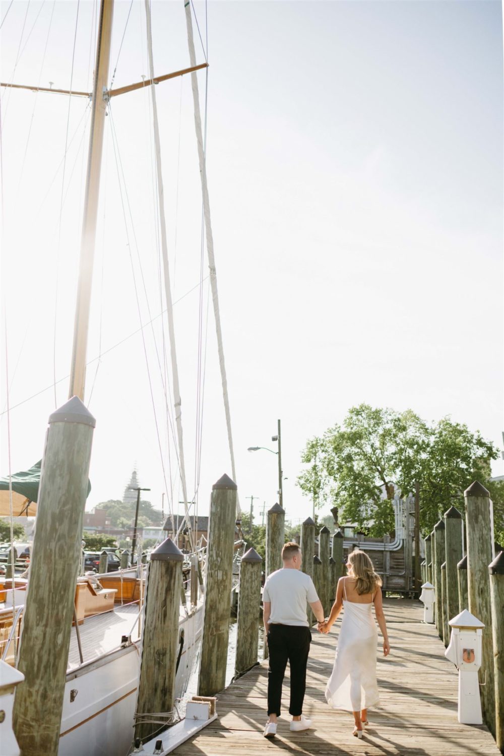 guy and girl holding hands walking annapolis marina