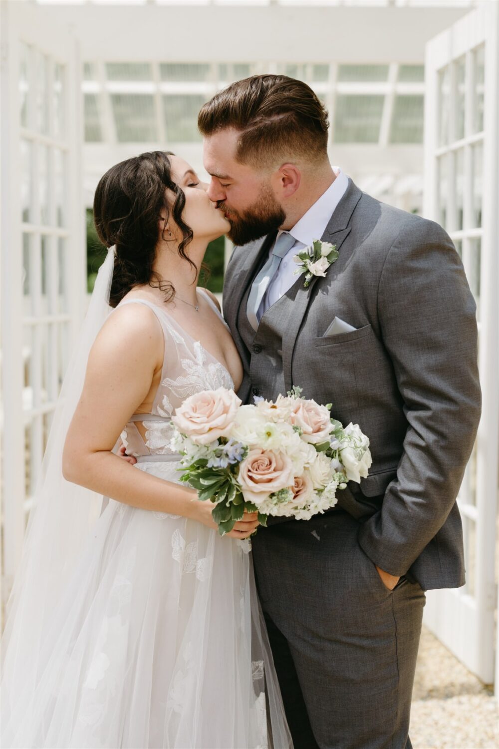 ivy rose barn bride and groom kissing wedding details florals