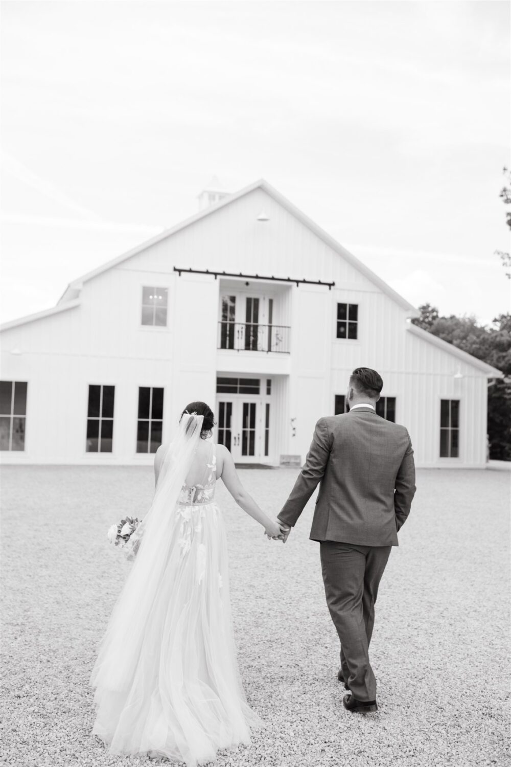 black and white wedding venue bride and groom holding hands