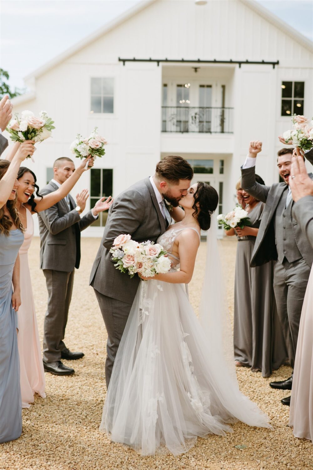 bride and groom kissing bridal party cheering smiling laughing