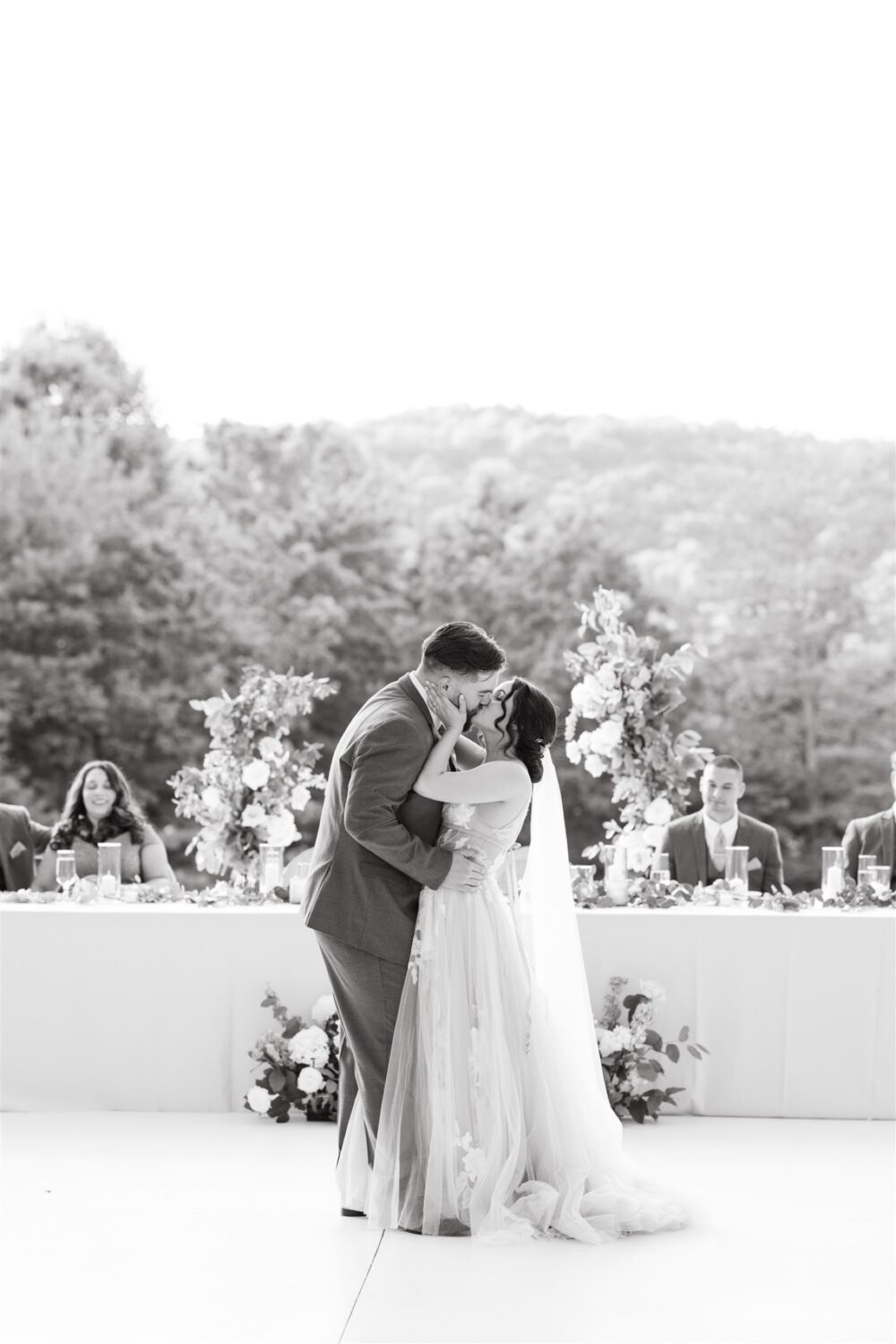 black and white portrait bride and groom kissing hugging