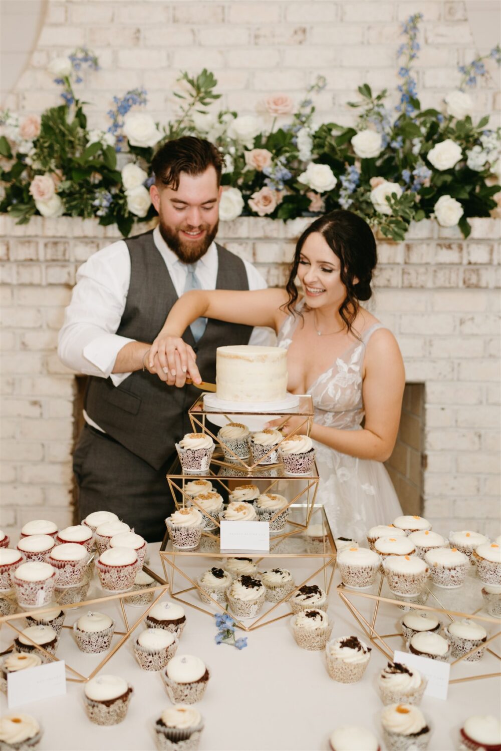 ivy rose barn bride and groom cutting wedding cake smiling wedding cupcakes