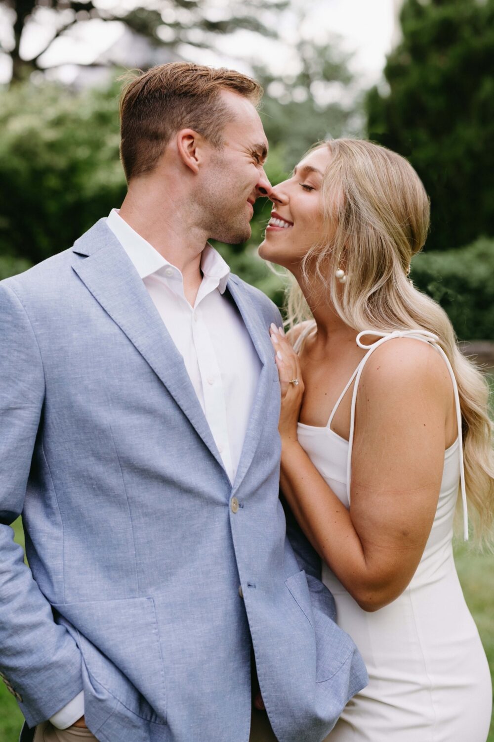 couple engagement portraits girl smiling and fiancé touching noses