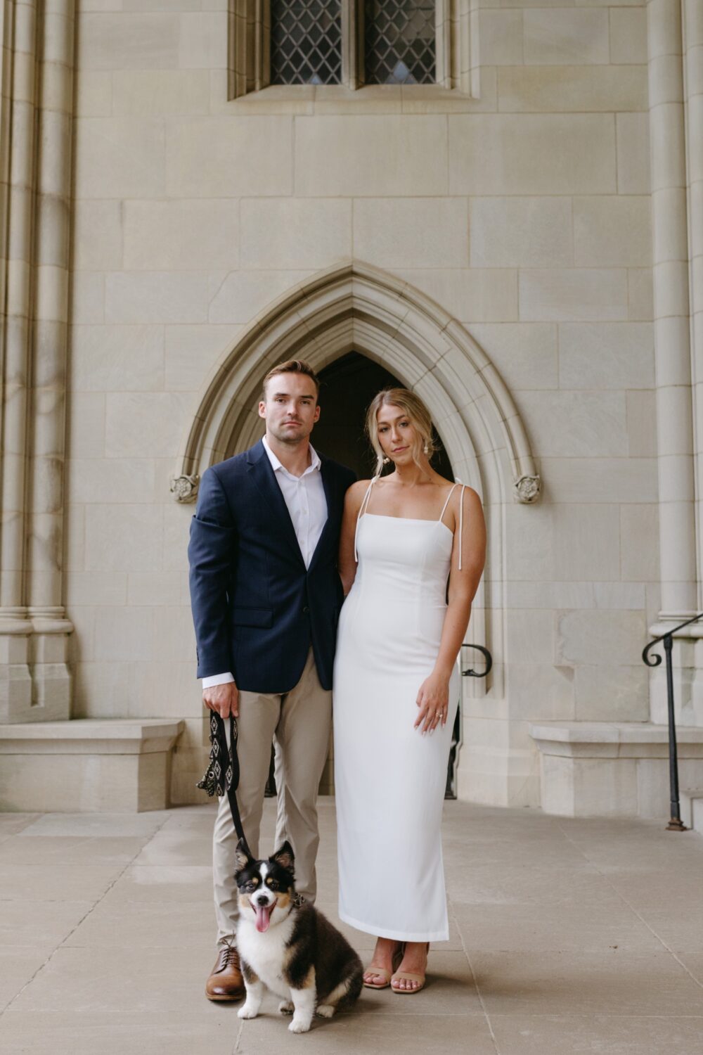 national cathedral engagement session bride and groom standing in archway with dog