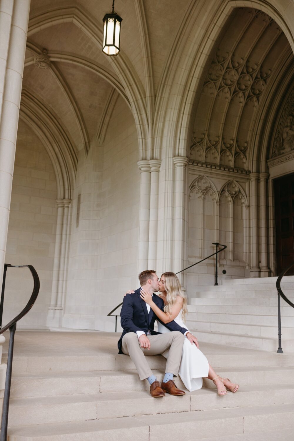 bride and groom kissing seated on steps national cathedral engagement session 