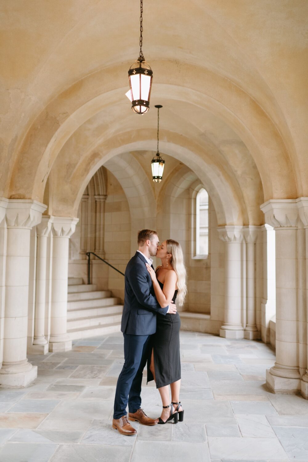 national cathedral engagement session couple standing in archway kissing