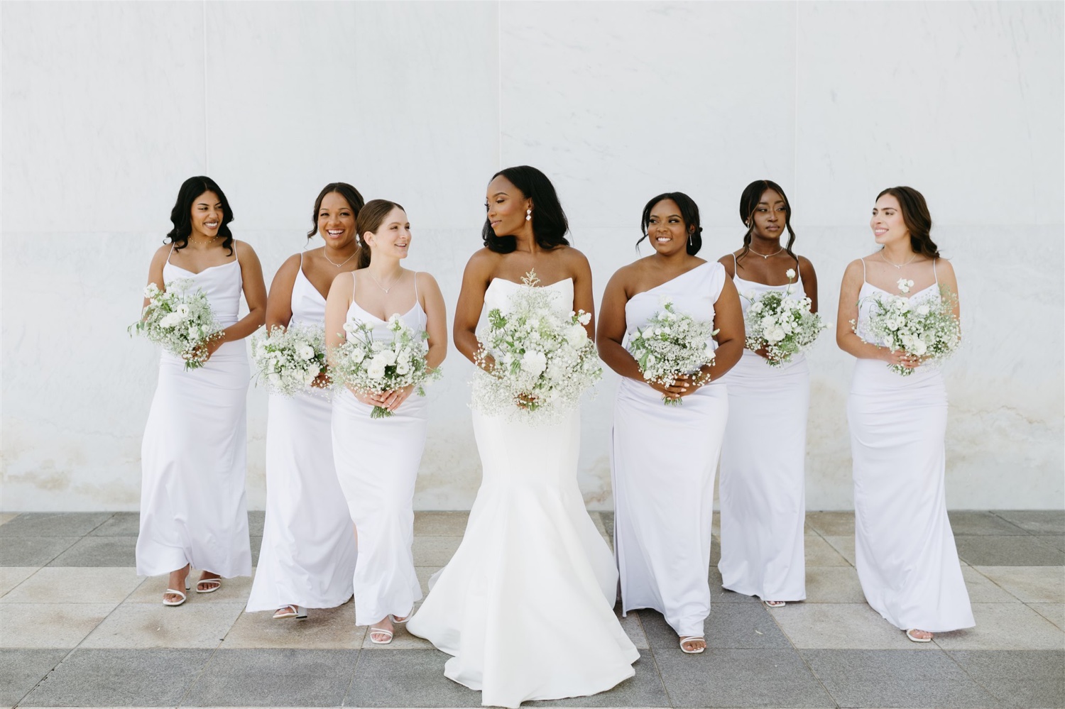 bride and bridesmaids all white dresses white florals