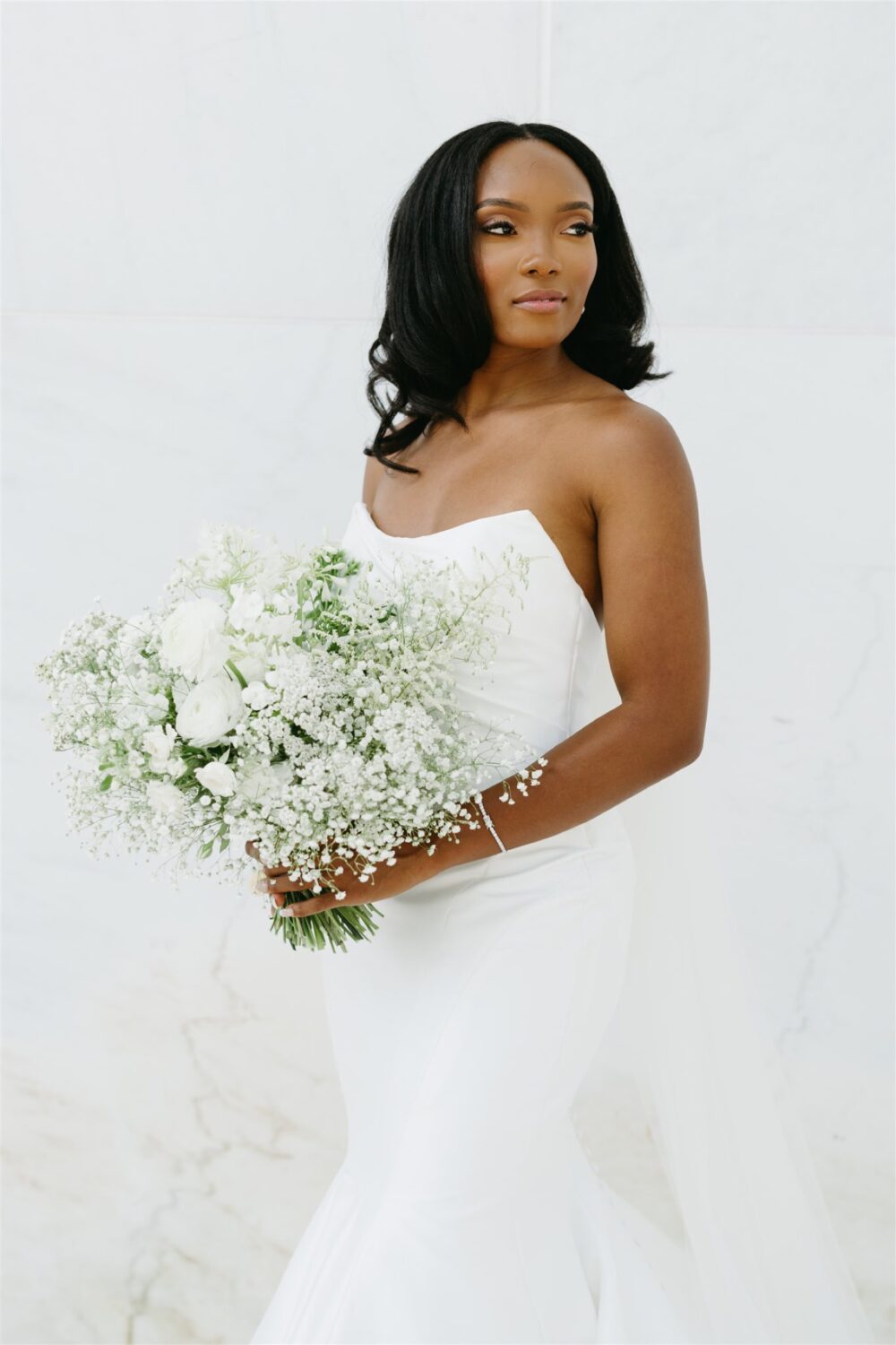 bridal portrait bride looking over her shoulder smiling white monochromatic bouquet