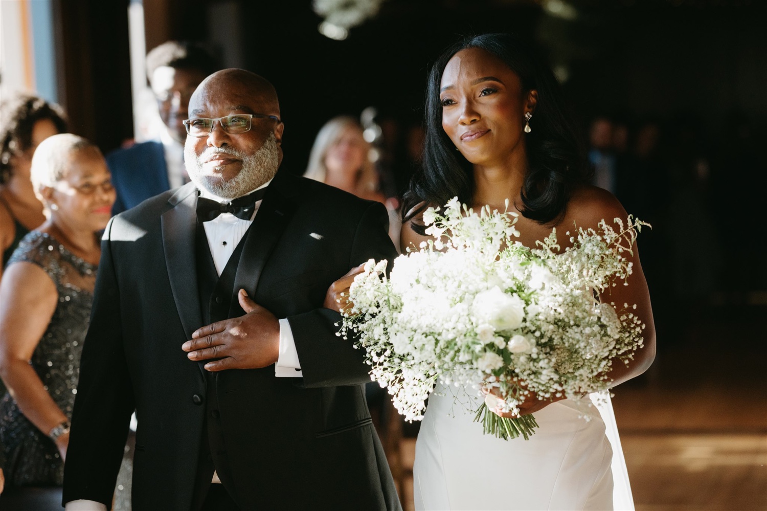 father walking daughter down the aisle black tux white floral details
