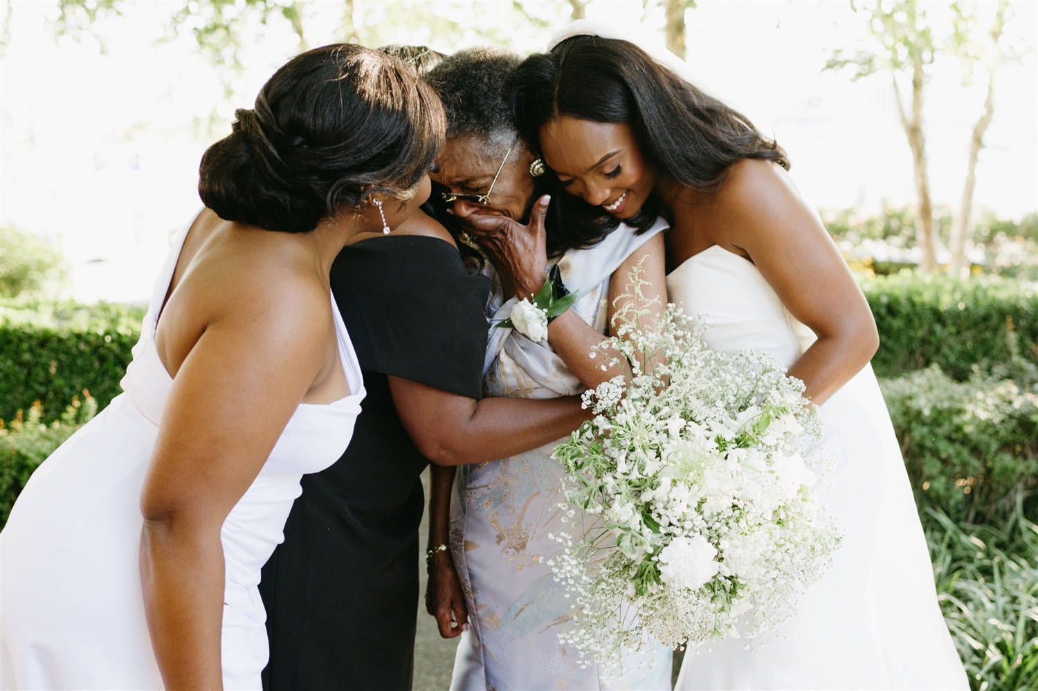 bride mother of the bride grandmother of the bride sister of the bride 3 generation family hugging grandmother holding back tears