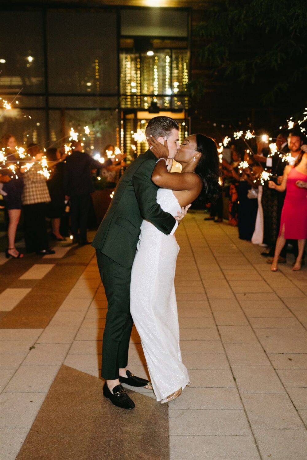 bride and groom firework wedding exit kissing at end of aisle
