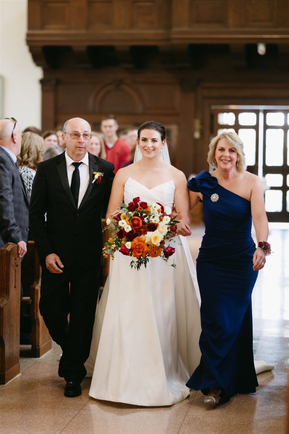 mother and father of the bride walking bride down the aisle fall colors Ways to Honor Your Mom on Your Wedding Day