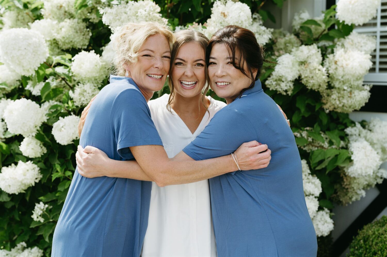 mother of the bride and mother of the groom bride hugging wedding day getting ready moment