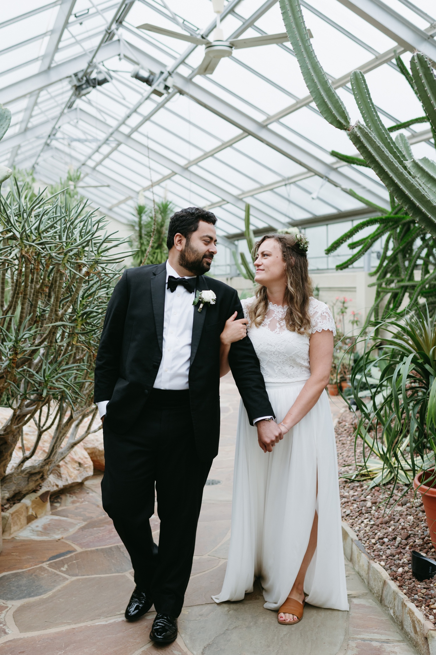 bride and groom posing in greenhouse desert flora