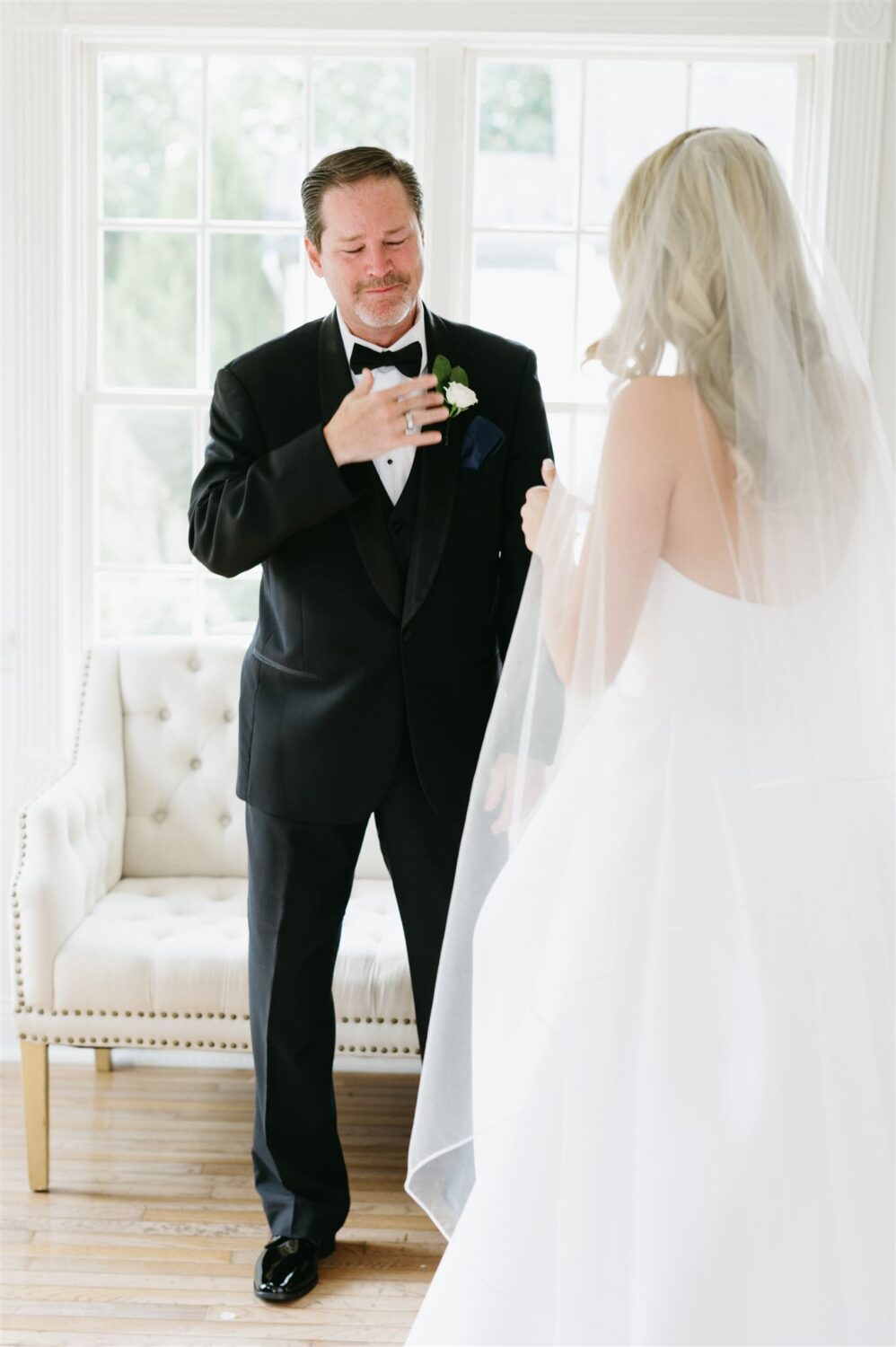 bride giving father first look wedding dress dad wearing black tux