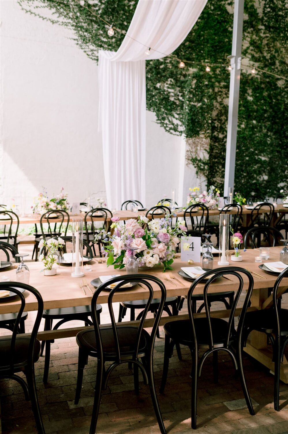 colorful modern industrial wedding reception pink lilac and blue florals black chair accents