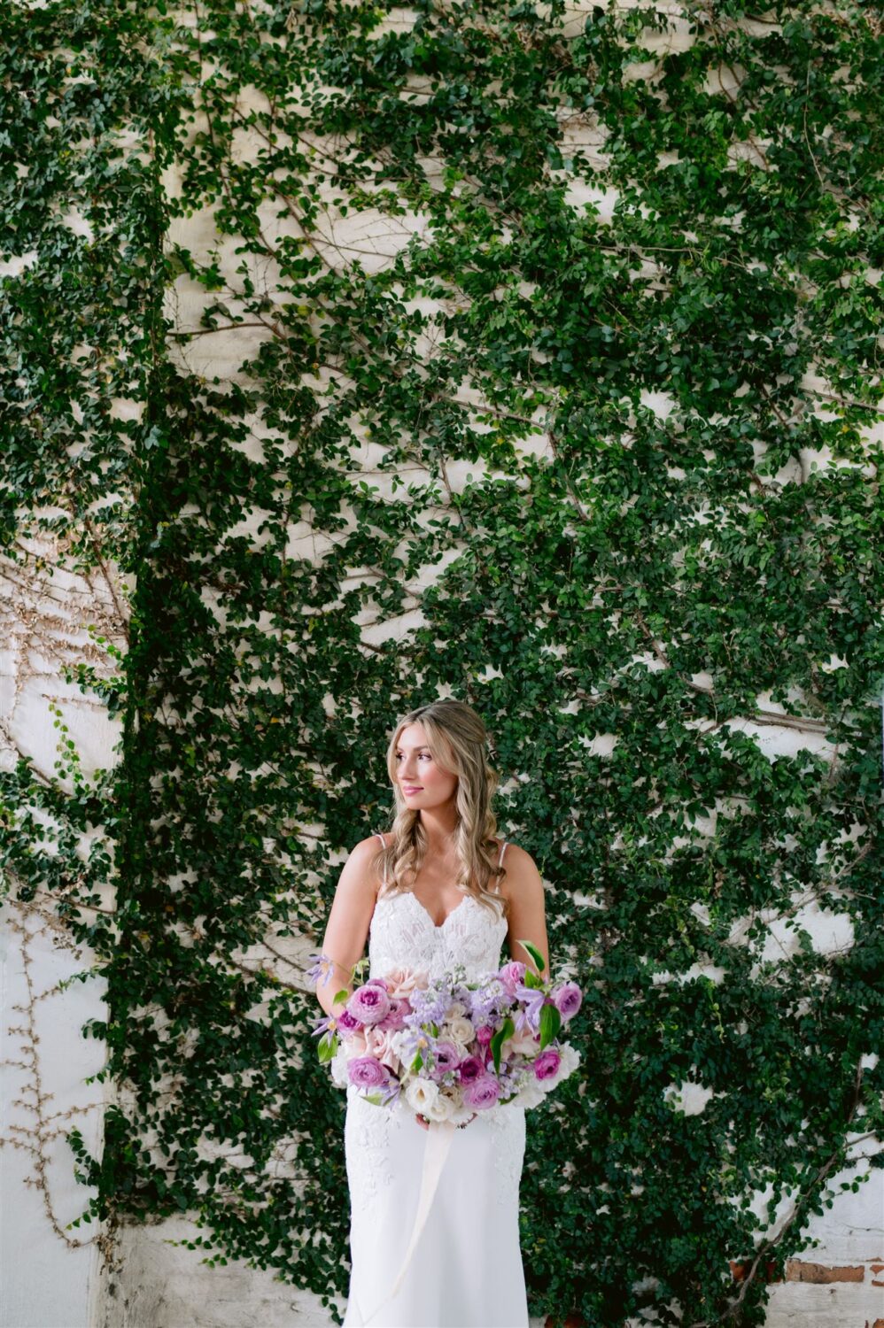 bride holding bridal bouquet pops of color pink and lilac 