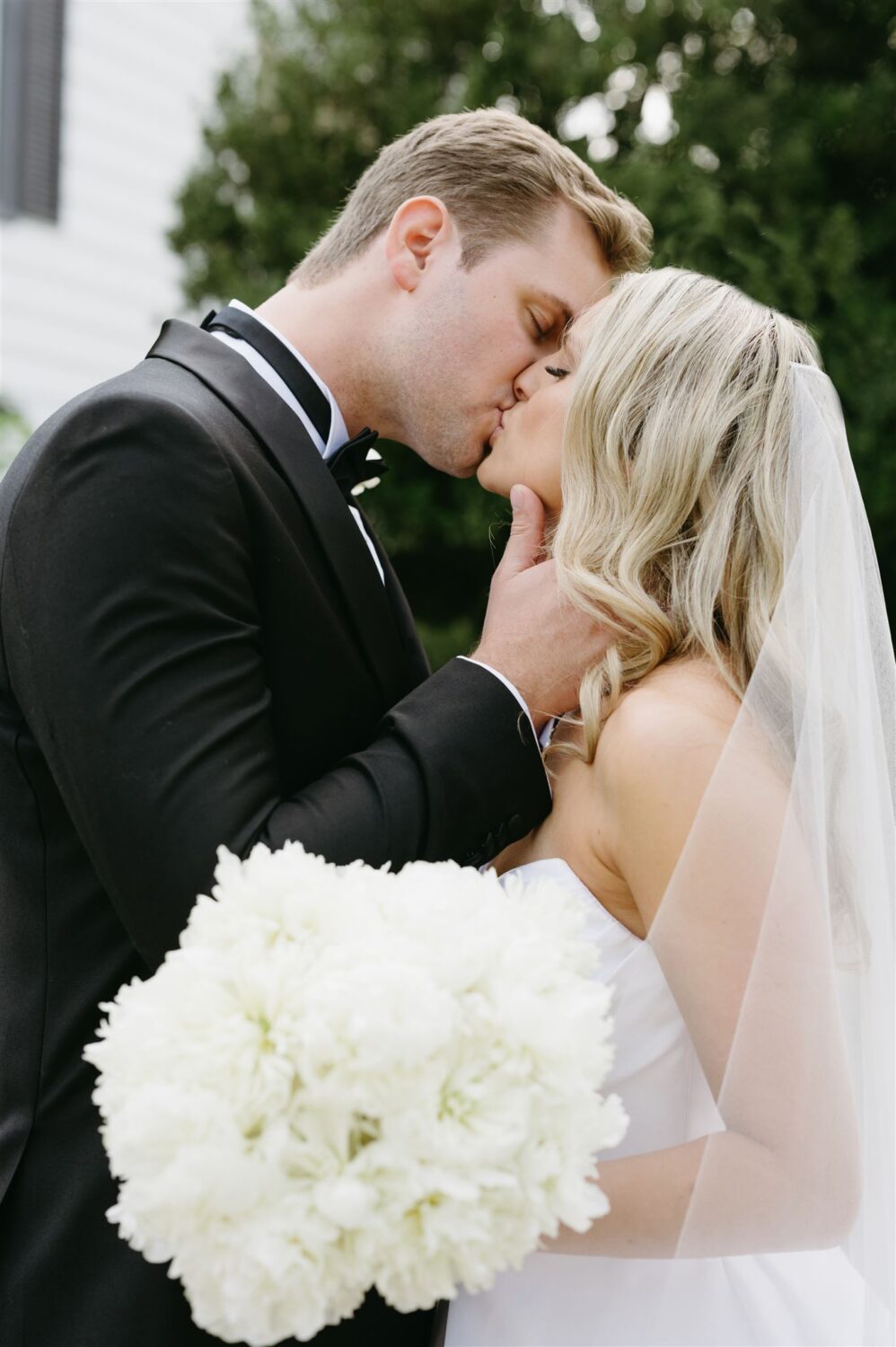 bride and groom kissing white bride wedding bouquet